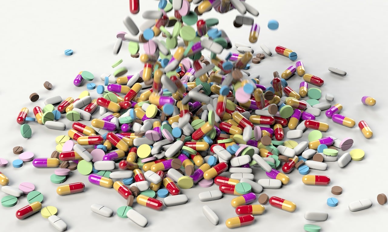 Medicines, pills and tablets falling on the table background.